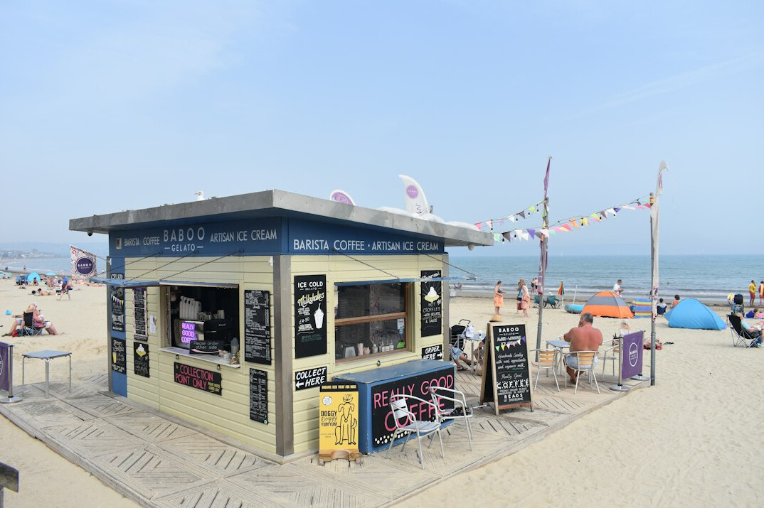 Families lining up at a seaside ice cream kiosk in summer